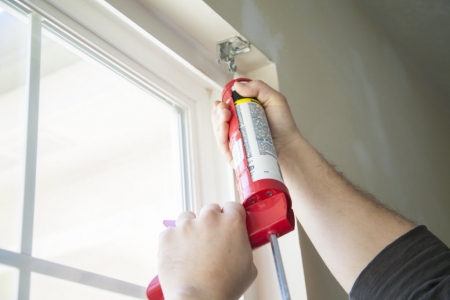 Man caulking a window